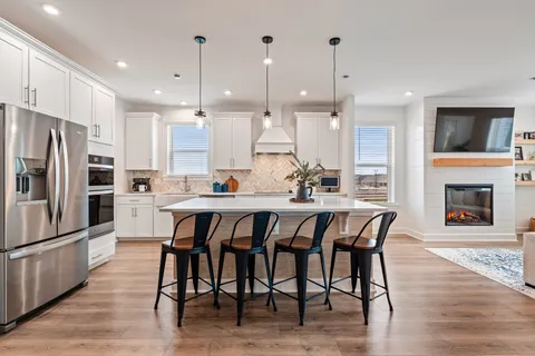 a large kitchen with a table chairs refrigerator and microwave