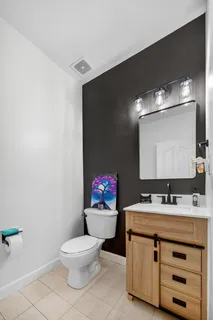 a bathroom with a toilet sink mirror and vanity