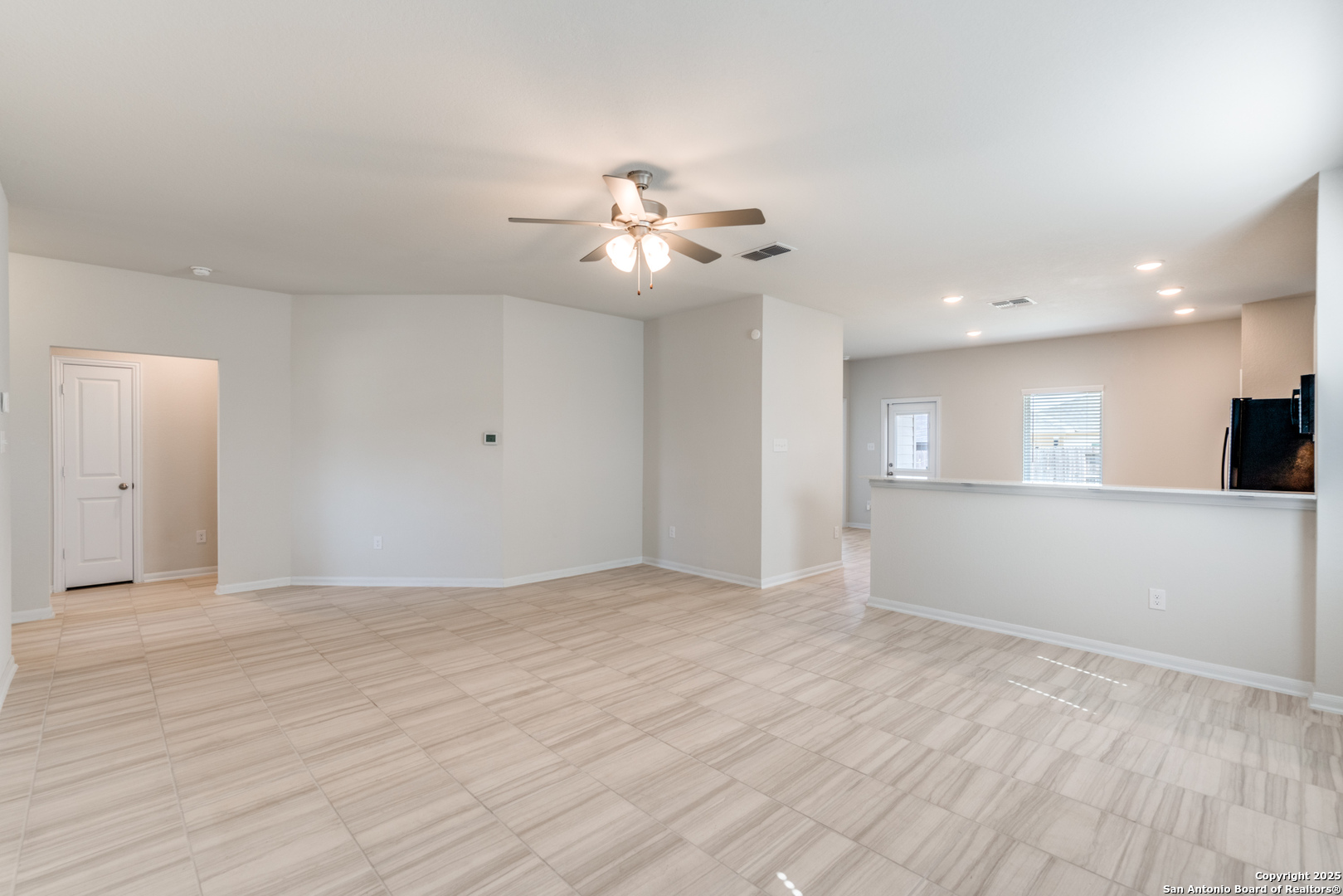 8931 Hazel Birch Elmendorf, TX 78112 - Photo 3 of 21 a view of an empty room with chandelier fan and wooden floor