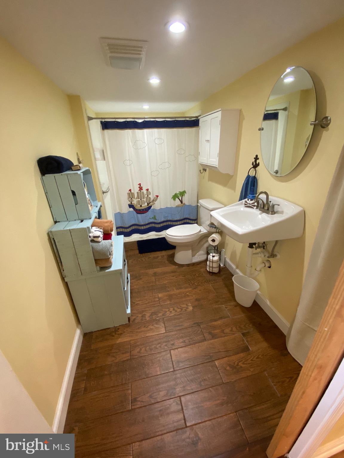 20805 Severn Road Ewell, MD 21824 - Photo 20 of 27 a living room with couches and kitchen view with wooden floor