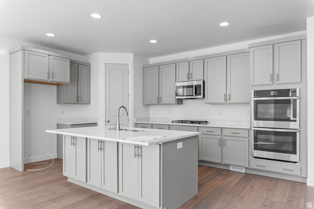 1024 South Tanner Road Santaquin, UT 84655 - Photo 12 of 20 Kitchen with stainless steel appliances, gray cabinets, a center island with sink, dark wood finished floors, and recessed lighting