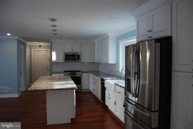 a kitchen with stainless steel appliances granite countertop refrigerator sink and stove