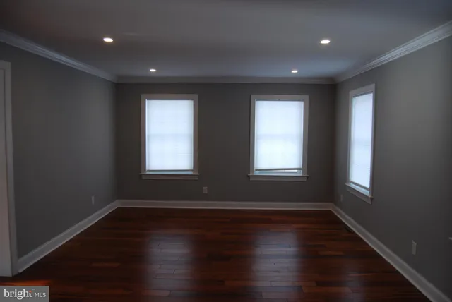 a empty room with wooden floor and windows