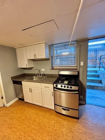 a kitchen with granite countertop a stove and a sink