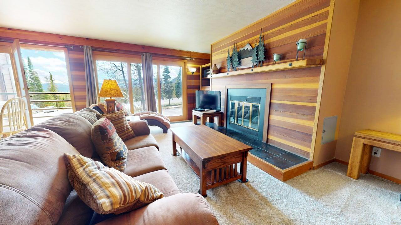 91200 Ryan Gulch Road, Unit 213 Silverthorne, CO 80498 - Photo 5 of 33 a living room with furniture and a fireplace