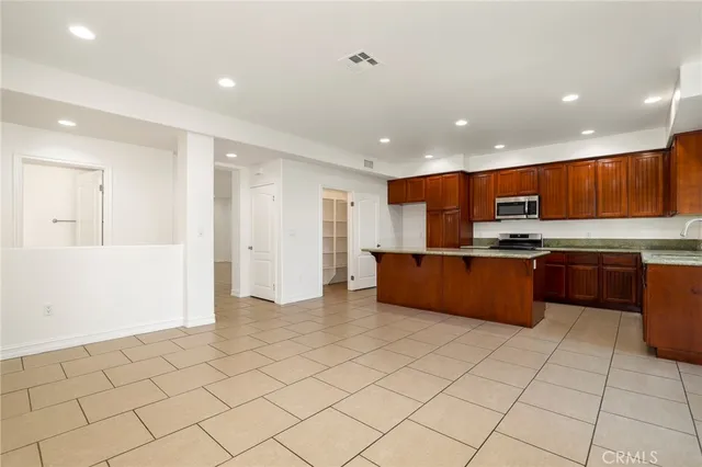 a kitchen with stainless steel appliances granite countertop a refrigerator and a sink
