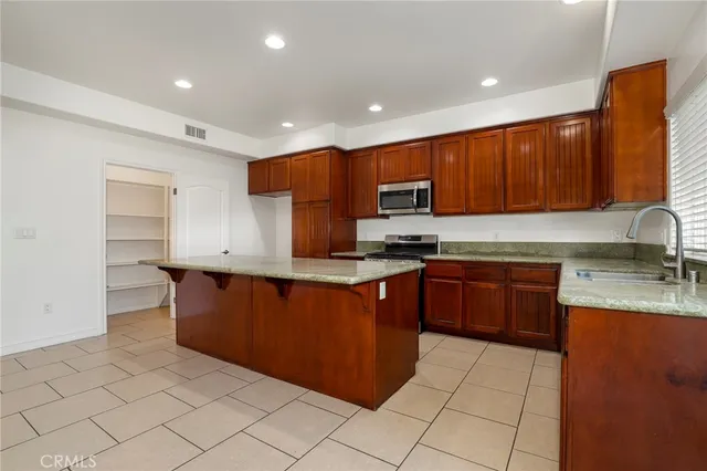 a kitchen with stainless steel appliances granite countertop a stove a sink and a refrigerator