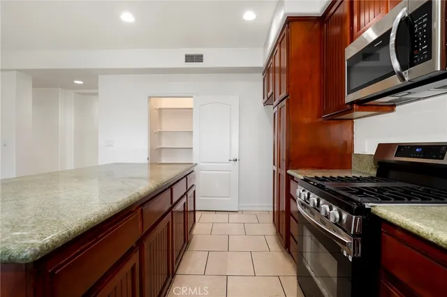 a kitchen with stainless steel appliances granite countertop a stove a sink and a microwave