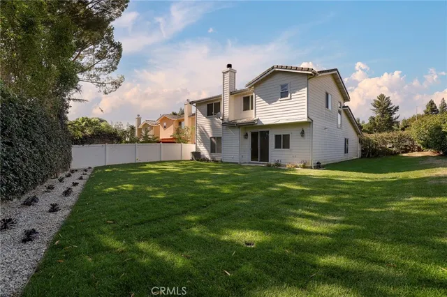 a view of a house with a big yard and large tree