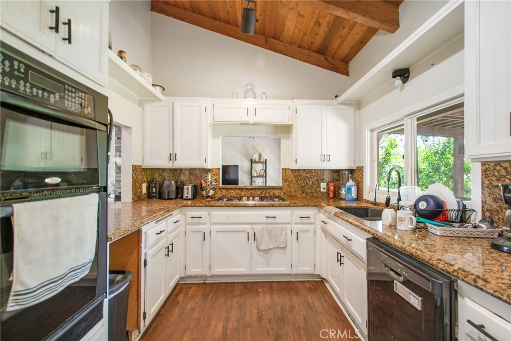 7241 Old Temescal Road Corona, CA 92881 - Photo 29 of 47 a kitchen with a sink white cabinets and white appliances