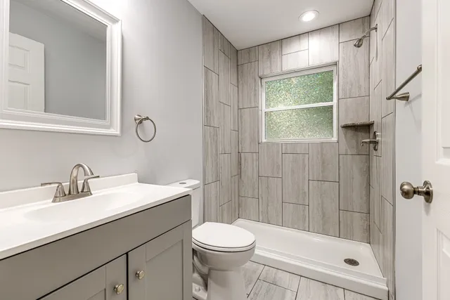 a bathroom with a sink a toilet and shower