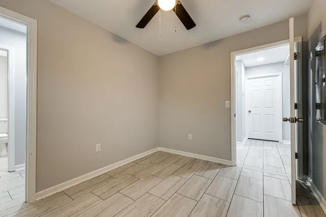 an empty room with a window and a fan