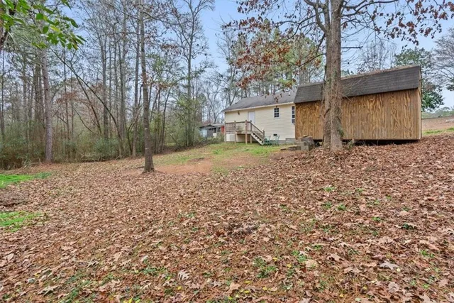 a backyard of a house with lots of green space and tall trees