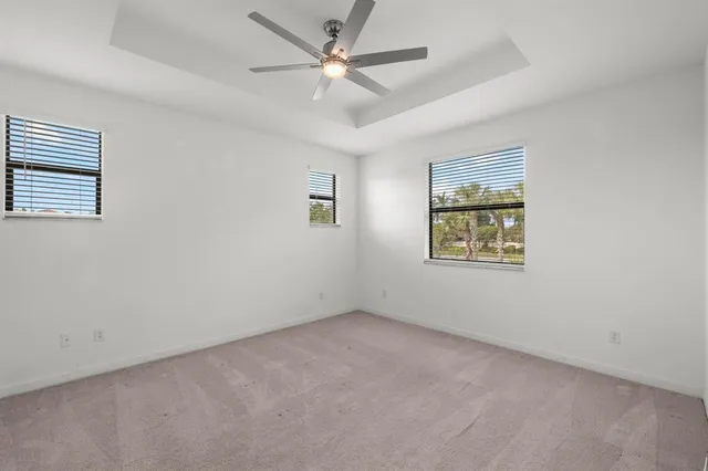 an empty room with a window and a fan