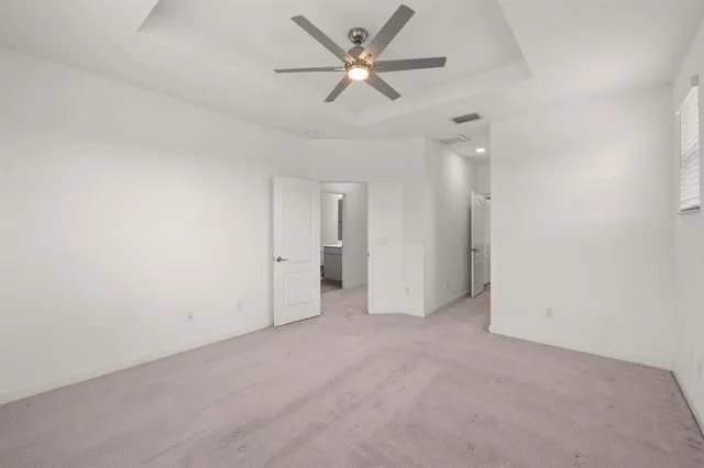 an empty room with closet and a ceiling fan
