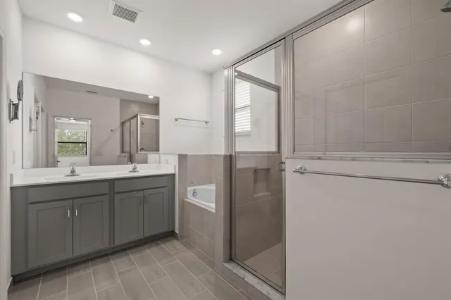 a bathroom with a double vanity sink a mirror and a shower