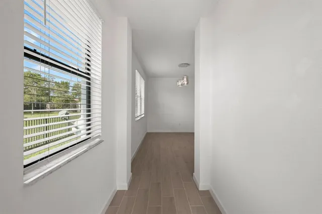 a view of a hallway with wooden floor and a window