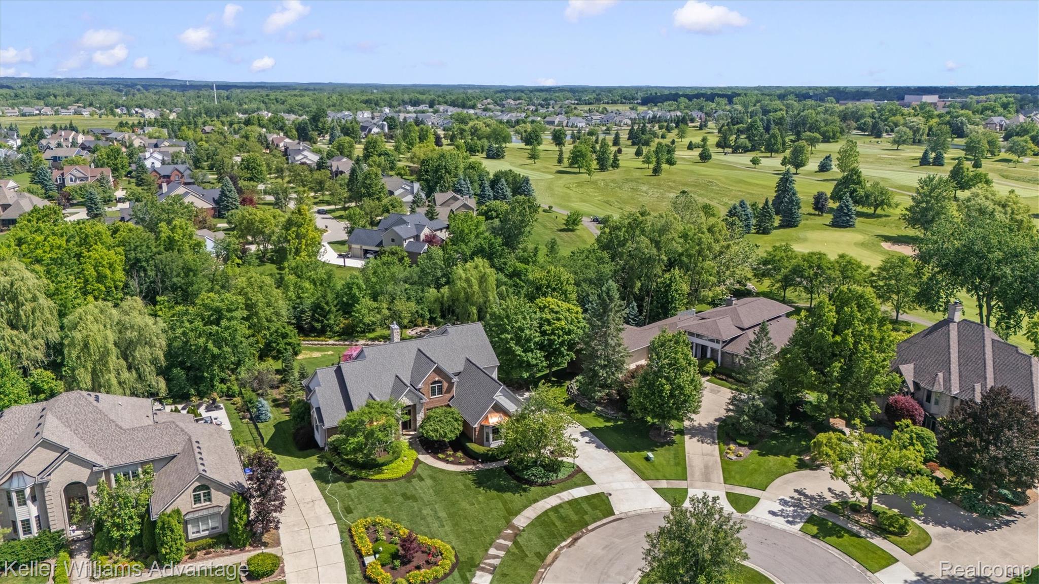 22878 Tree Top Court South Lyon, MI 48178 - Photo 61 of 75 Expansive property featuring a brick and stone facade, a dark shingle roof, and a meticulously landscaped front yard with a circular driveway