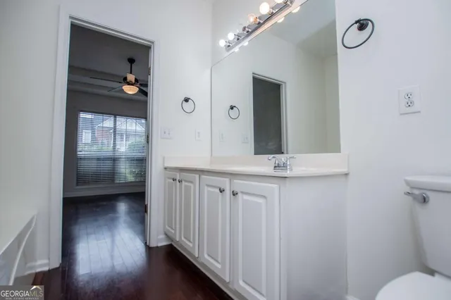 a bathroom with a sink a mirror a toilet and a window