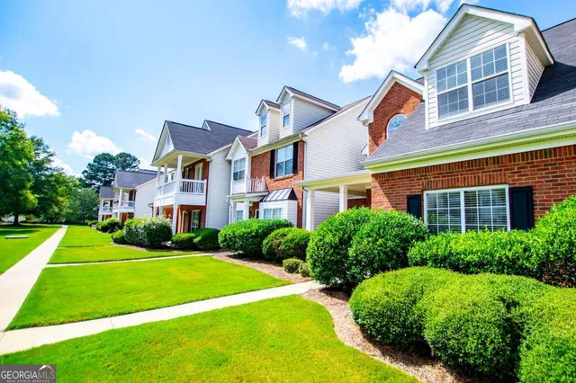 a front view of a house with yard and green space