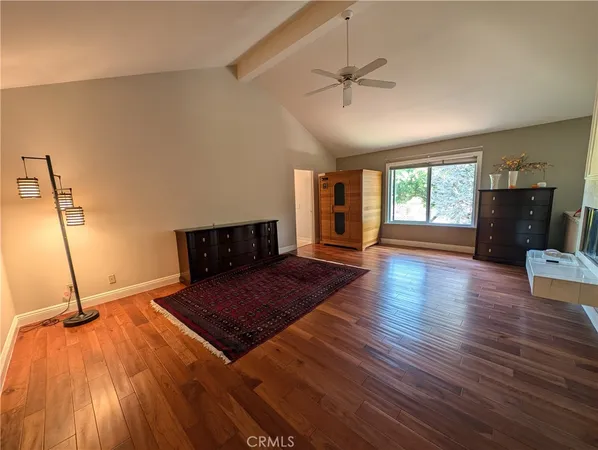 a living room with hard wood floors and a bed