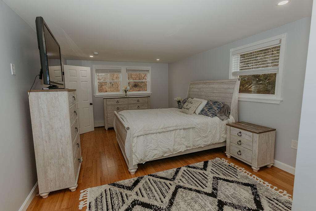 9 Rip Van Winkle Way Buzzards Bay, MA 02532 - Photo 13 of 56 a bedroom with a bed and wooden floor