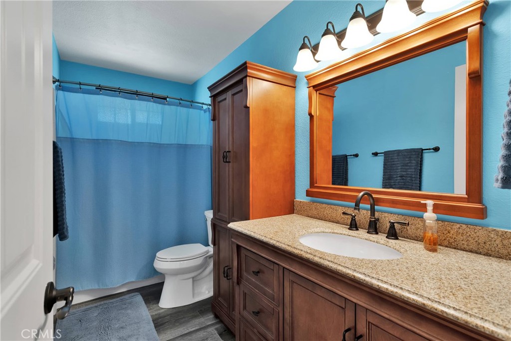 19095 Munsee Road Apple Valley, CA 92307 - Photo 22 of 58 a bathroom with a granite countertop sink toilet a mirror and shower