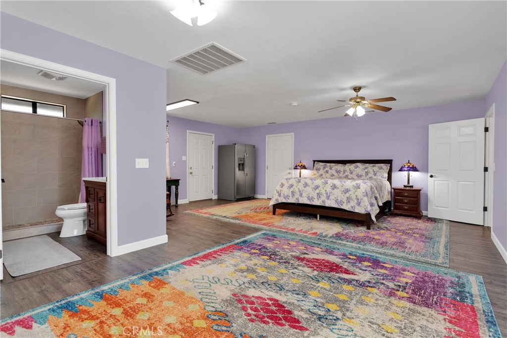 19095 Munsee Road Apple Valley, CA 92307 - Photo 27 of 58 a spacious bedroom with a bed and a lamp