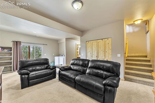 1055 Timber Ridge Road Divide, CO 80814 - Photo 20 of 47 Carpeted living room featuring stairway