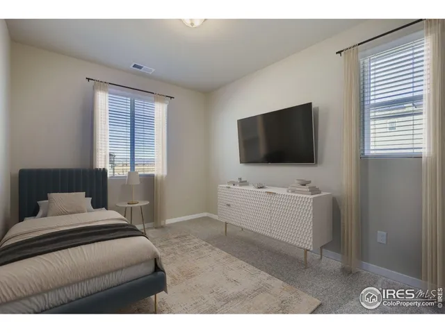 a hotel room with a flat screen tv on dresser and a window