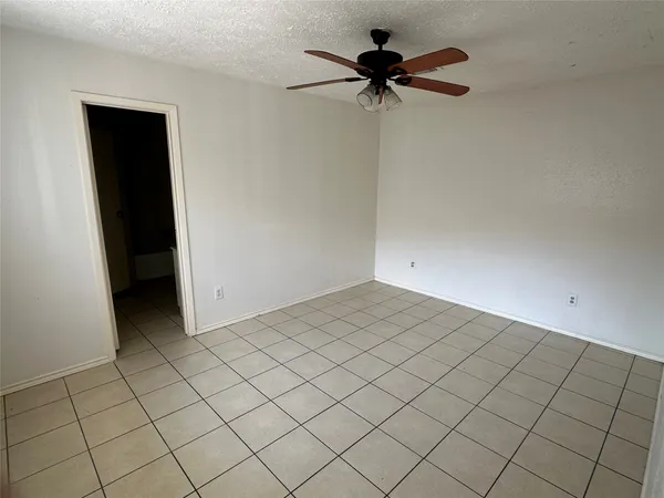 a view of a room with a ceiling fan and a rug