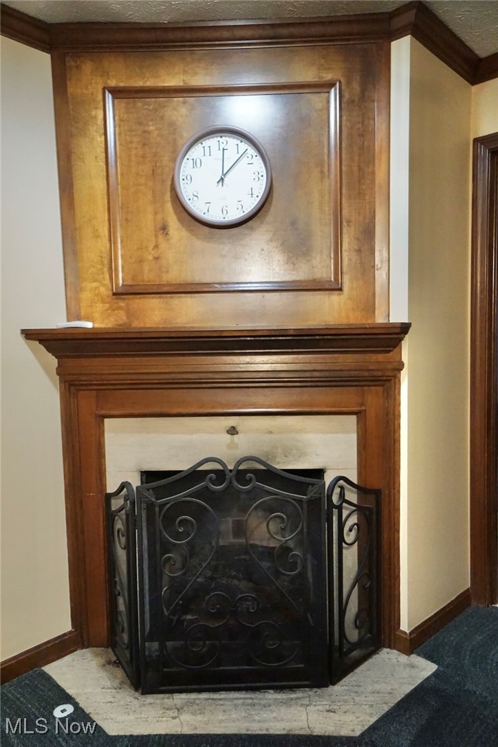 1760 Chartley Road Gates Mills, OH 44040 - Photo 19 of 49 Detailed view of master bedroom fireplace with flush hearth, a textured ceiling, crown molding, and carpet