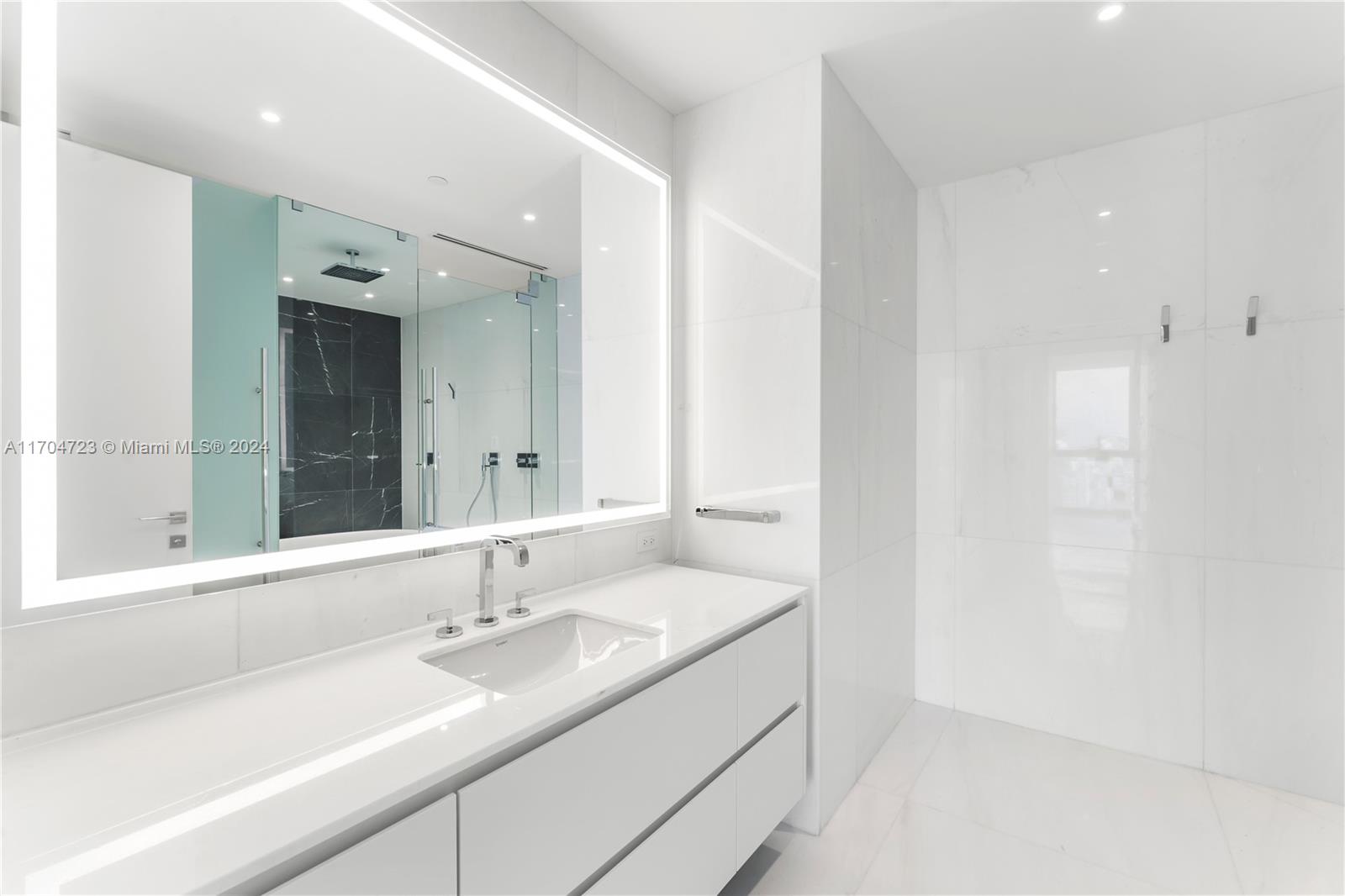 300 Biscayne Blvd Way, Unit 5209 Miami, FL 33131 - Photo 11 of 42 a bathroom with a sink and a large mirror