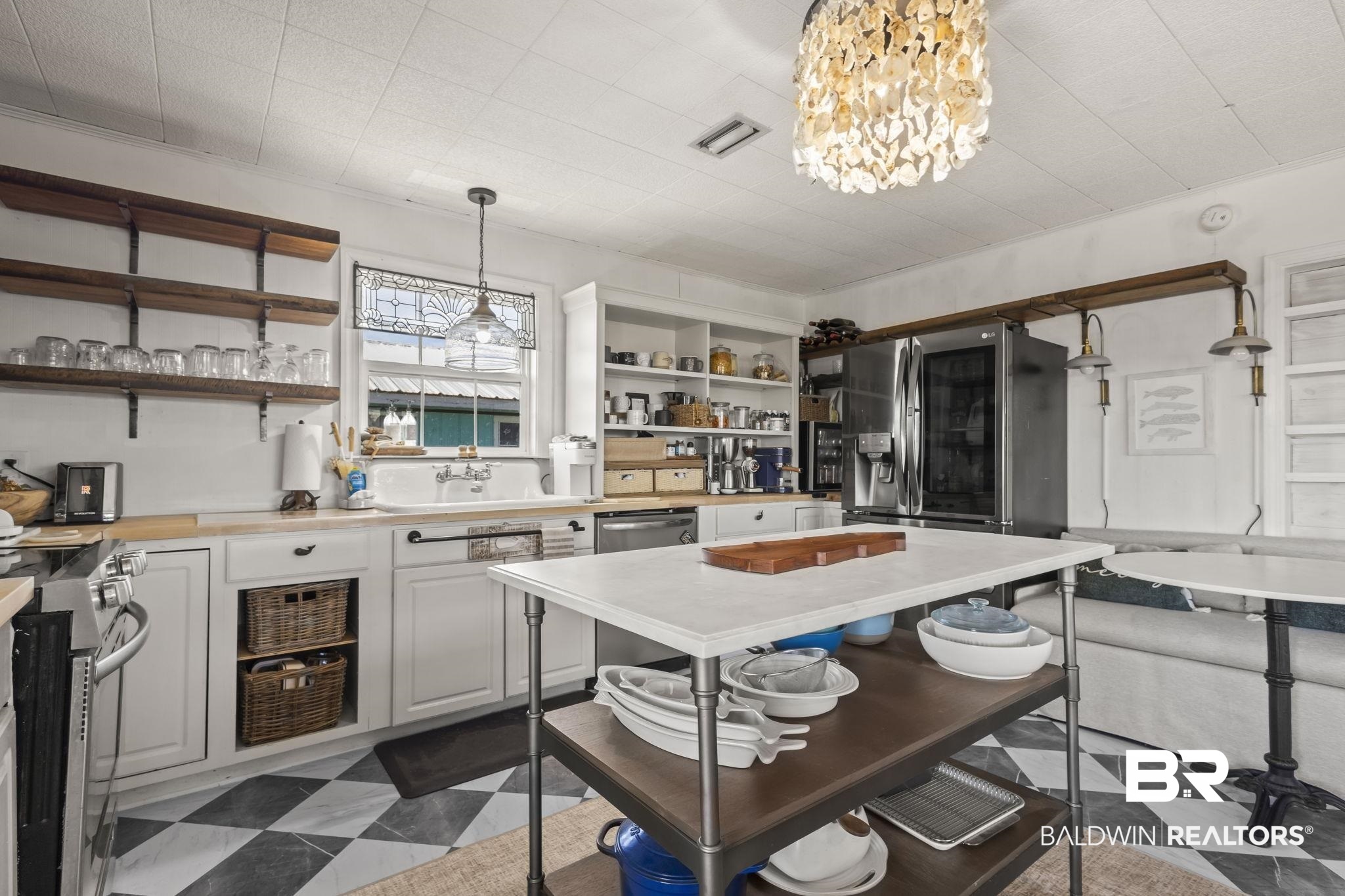 2514 Muscogee Road Gulf Shores, AL 36542 - Photo 12 of 60 Kitchen with a notable chandelier, white cabinets, sink, decorative light fixtures, and stainless steel appliances