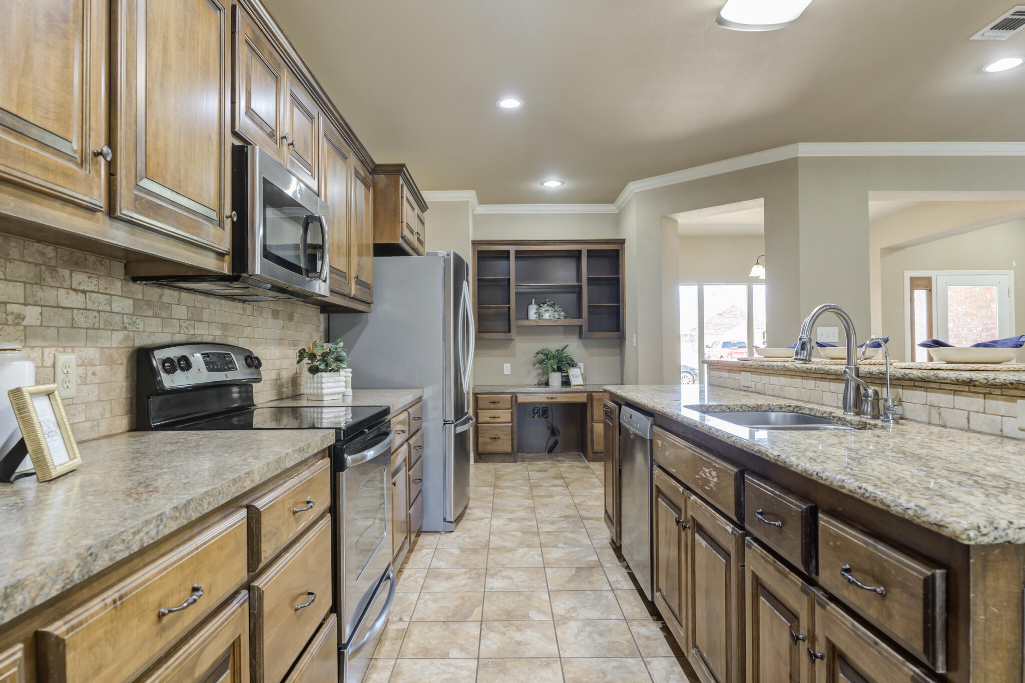 6512 71st Street Lubbock, TX 79424 - Photo 14 of 41 a kitchen with stainless steel appliances granite countertop counter space a sink and cabinets