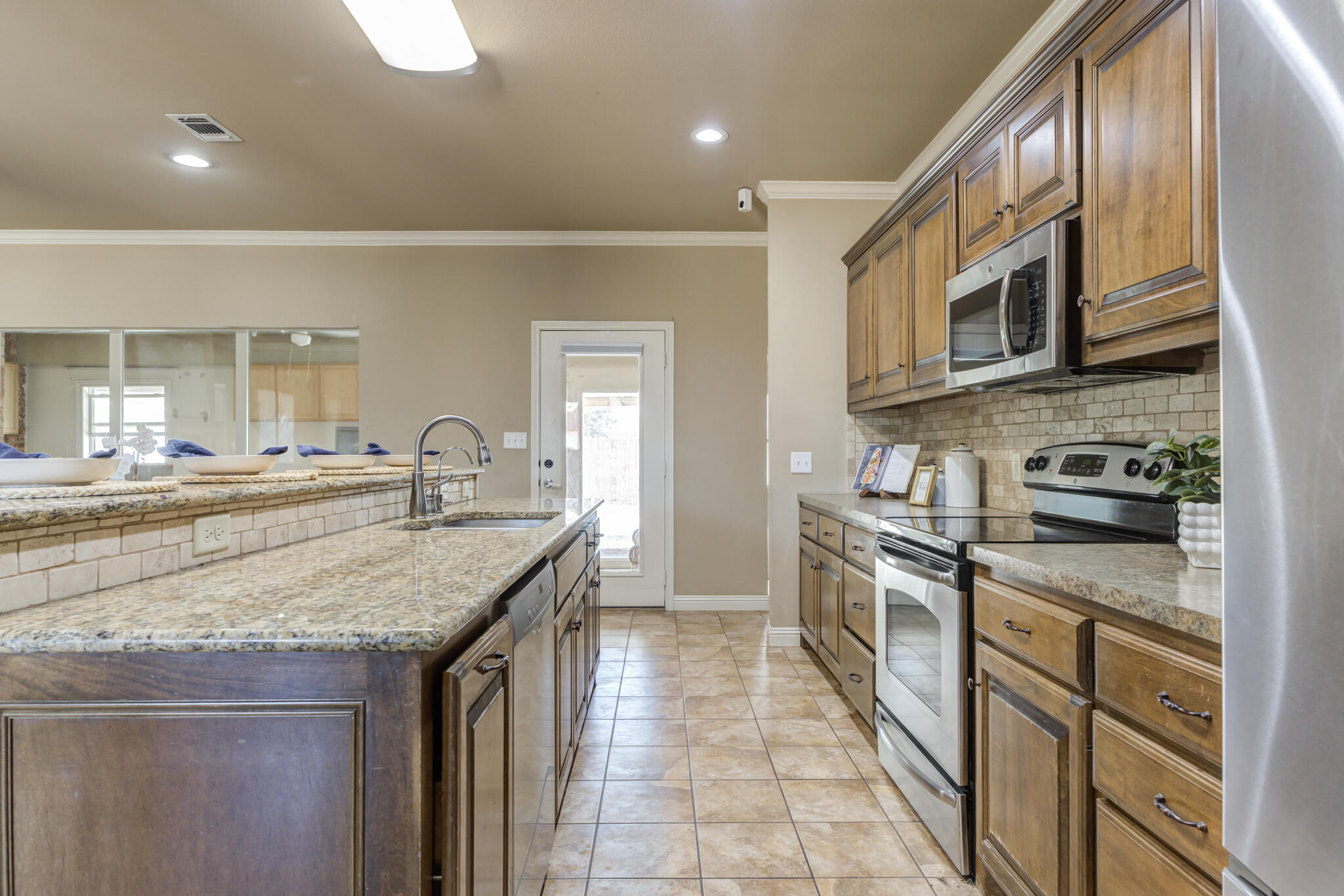 6512 71st Street Lubbock, TX 79424 - Photo 16 of 41 a kitchen with stainless steel appliances granite countertop a stove and cabinets
