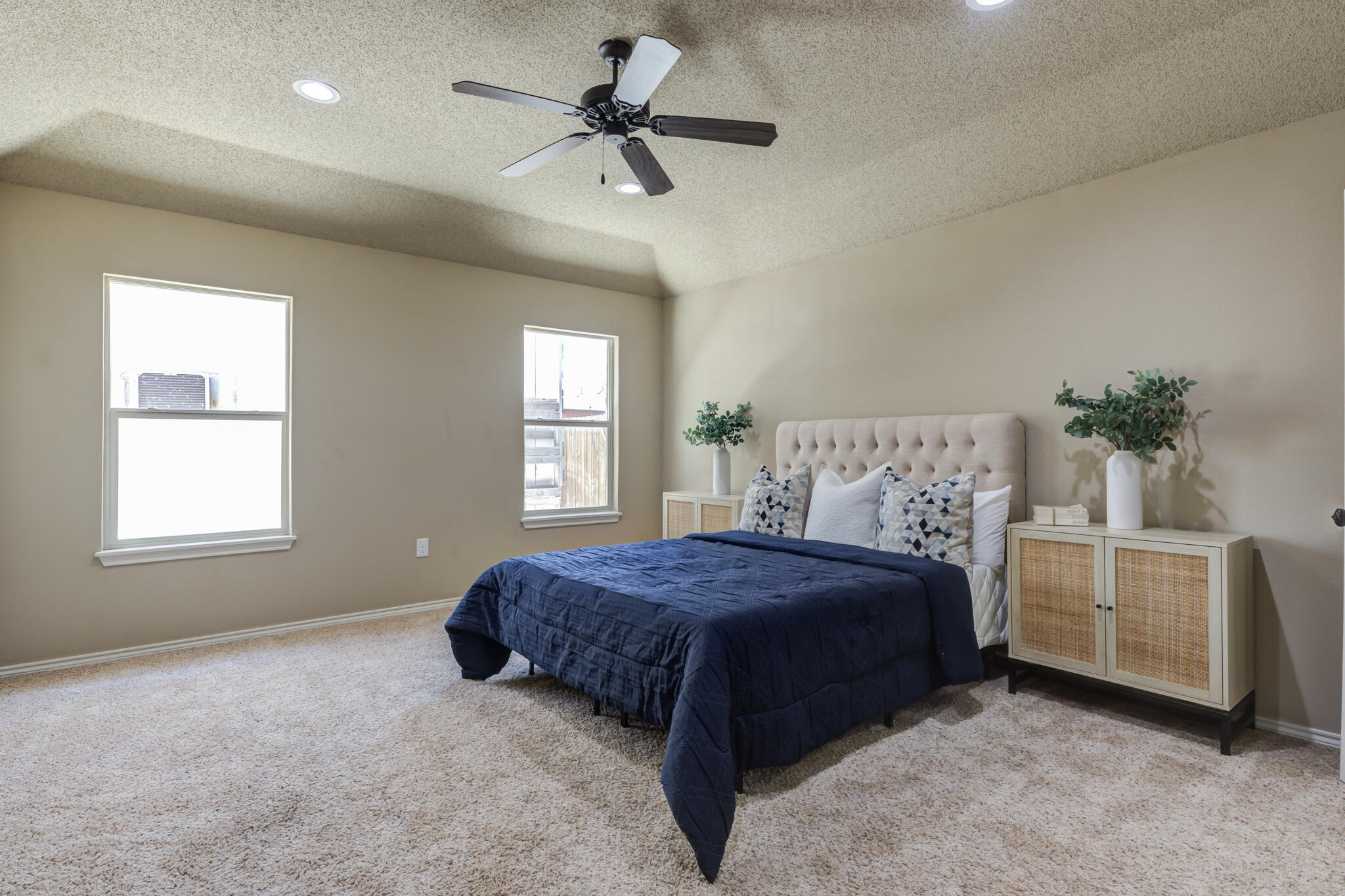 6512 71st Street Lubbock, TX 79424 - Photo 21 of 41 a spacious bedroom with a bed a ceiling fan and a couch