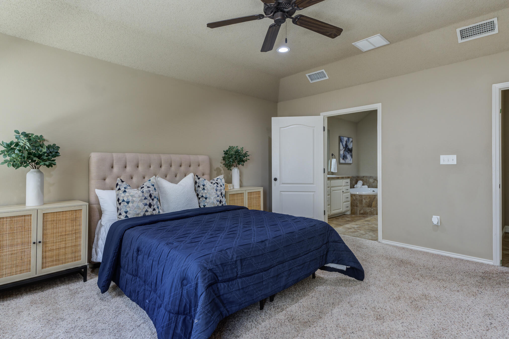 6512 71st Street Lubbock, TX 79424 - Photo 23 of 41 a bedroom with a large bed and a chandelier