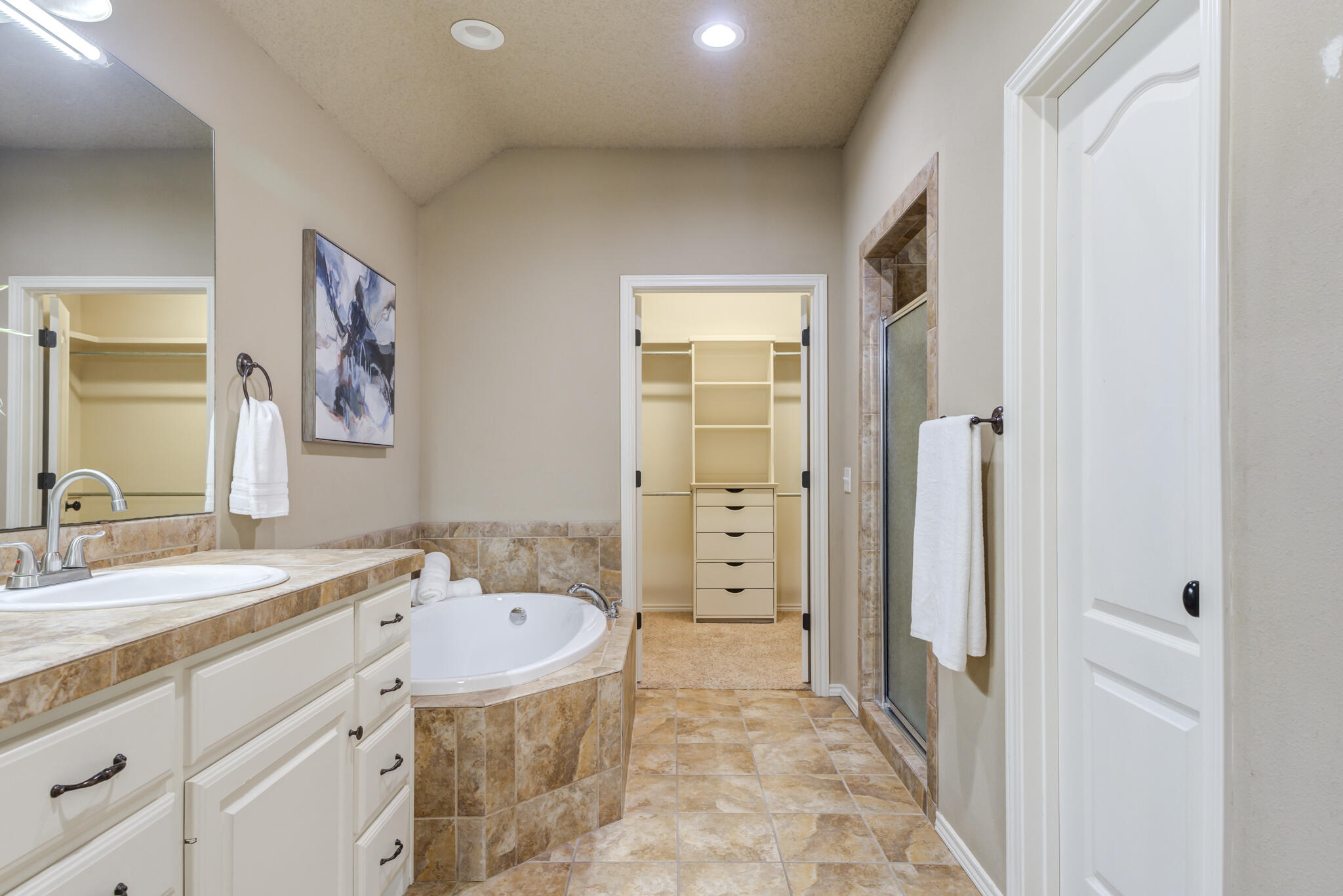 6512 71st Street Lubbock, TX 79424 - Photo 24 of 41 a spacious bathroom with a granite countertop sink and a mirror
