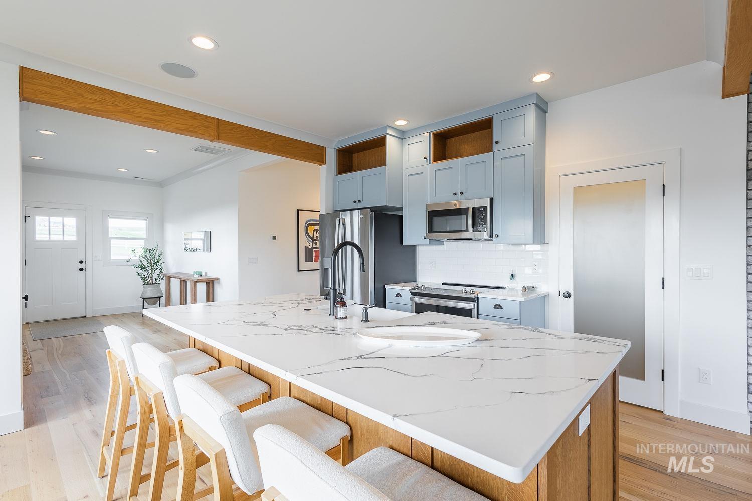 11171 Pump Road Nampa, ID 83686 - Photo 12 of 50 Central kitchen island with a waterfall countertop, integrated sink, and matte black faucet