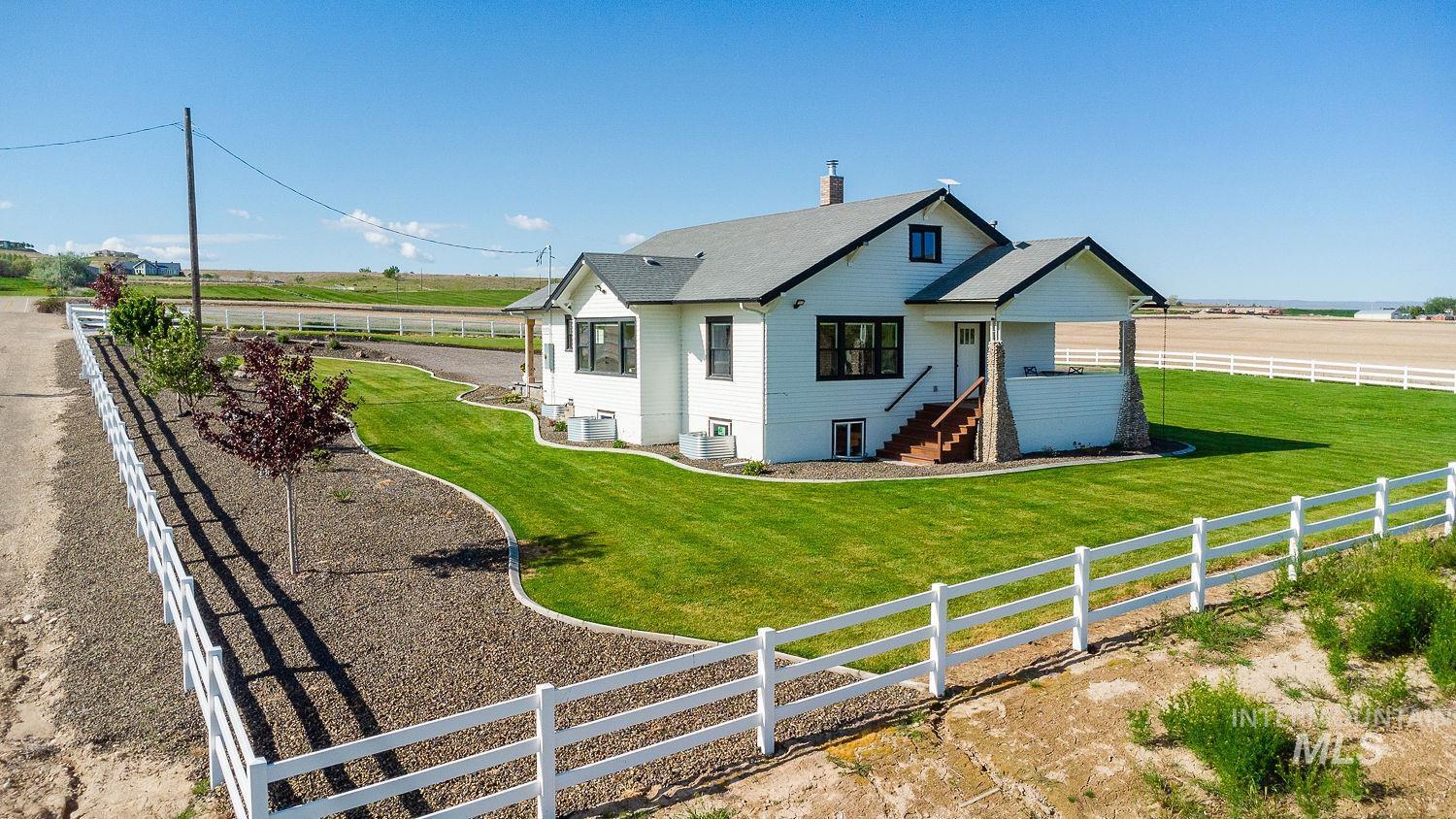 11171 Pump Road Nampa, ID 83686 - Photo 2 of 50 White vinyl fencing encloses the expansive property, featuring a manicured lawn and mature landscaping