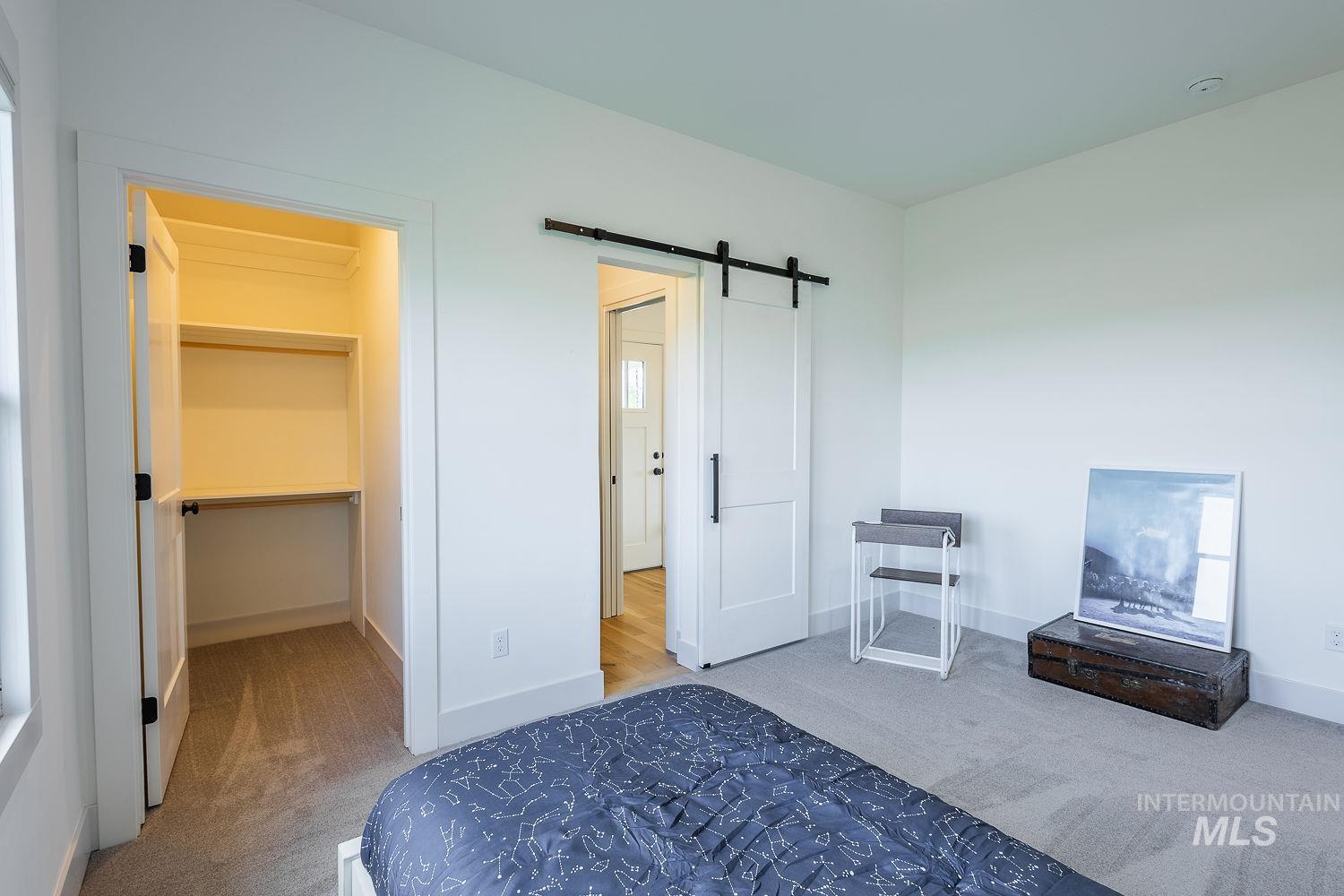 11171 Pump Road Nampa, ID 83686 - Photo 24 of 50 Bedroom featuring light gray carpeting, crisp white walls, and a recessed closet with built-in shelving and hanging rods