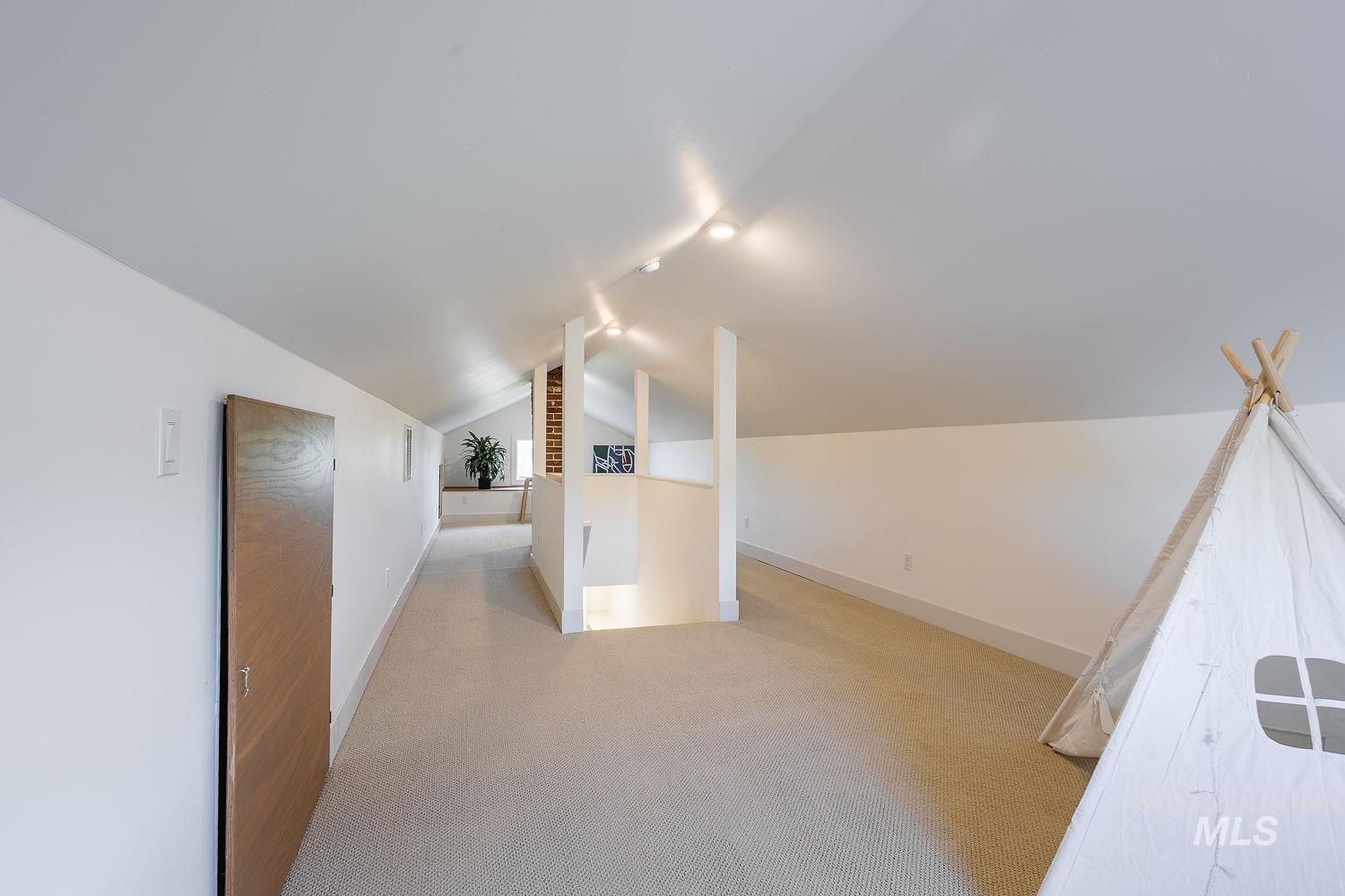 11171 Pump Road Nampa, ID 83686 - Photo 29 of 50 Carpeted loft area featuring a vaulted ceiling with track lighting, white walls, and a wood-finish door