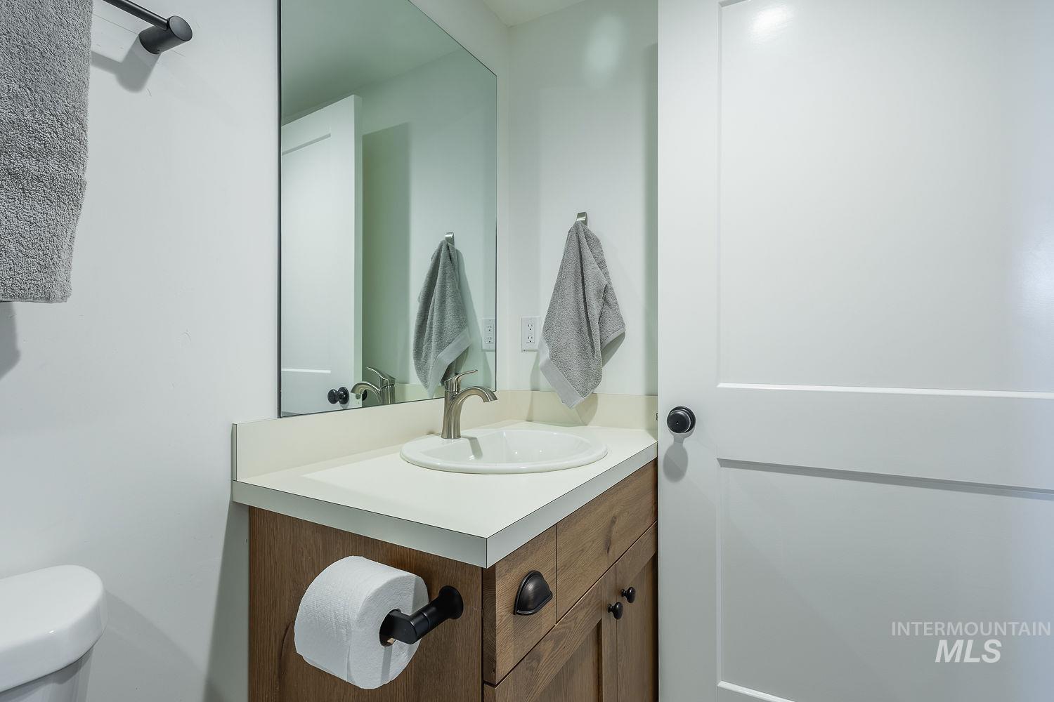 11171 Pump Road Nampa, ID 83686 - Photo 34 of 50 Bathroom vanity featuring a wood-finish cabinet, light-toned countertop, and undermount sink with a brushed nickel faucet
