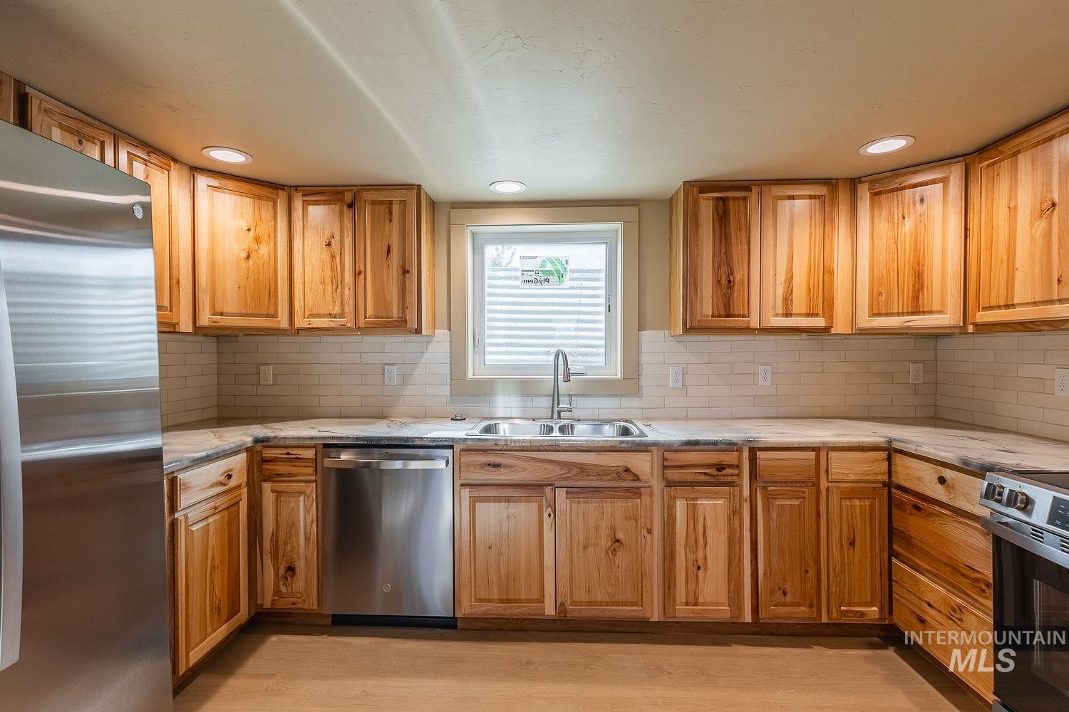 11171 Pump Road Nampa, ID 83686 - Photo 39 of 50 Kitchen featuring wood cabinetry, light-toned countertops, and a subway tile backsplash