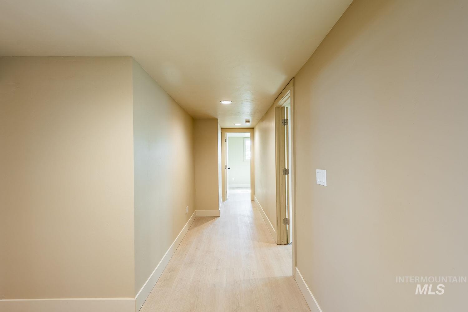 11171 Pump Road Nampa, ID 83686 - Photo 40 of 50 Hallway featuring light wood-finish flooring, recessed ceiling lighting, neutral wall tones, white baseboards, and interior doors with light-toned trim