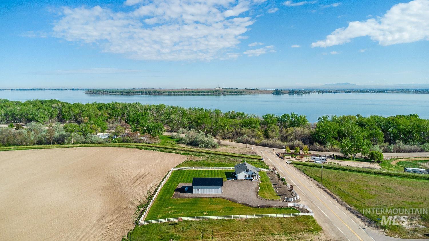 11171 Pump Road Nampa, ID 83686 - Photo 5 of 50 Expansive property featuring a white residence with dark roofing, a detached garage, and a manicured lawn