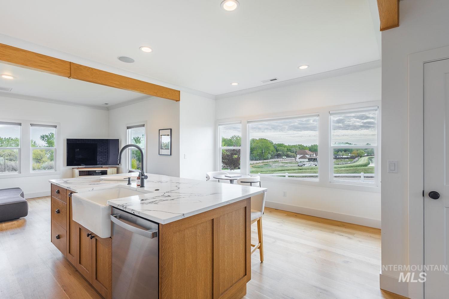 11171 Pump Road Nampa, ID 83686 - Photo 9 of 50 Kitchen island featuring a farmhouse sink, stainless steel dishwasher, and a veined countertop