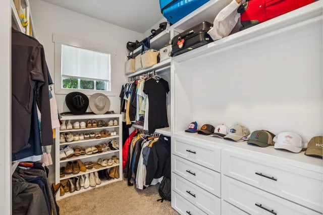 a view of walk in closet with clothes and shoes