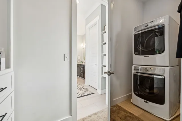 a utility room with stainless steel appliances wooden floor washer and dryer